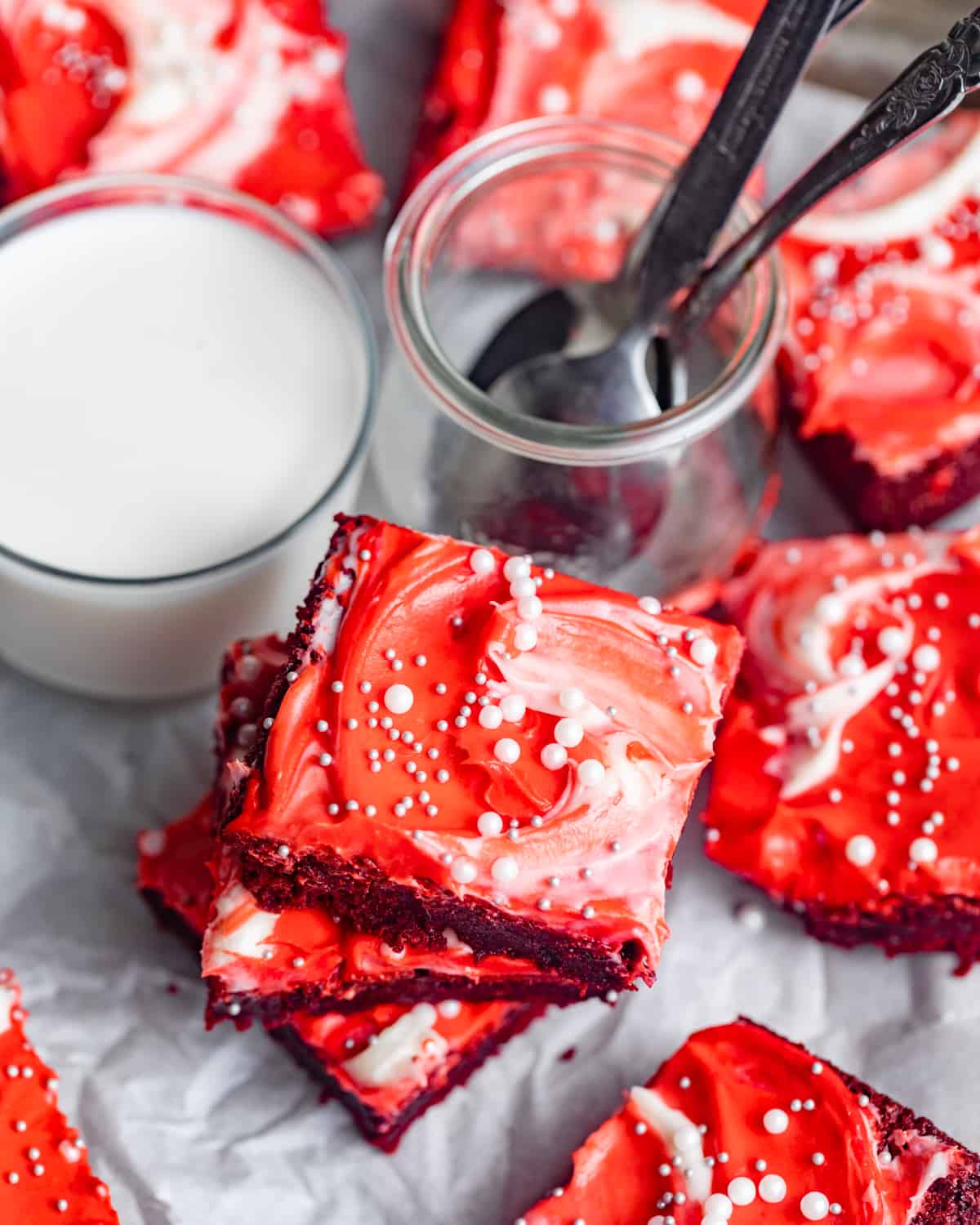 red velvet brownies on a serving platter cut into square pieces next to a glass of milk.