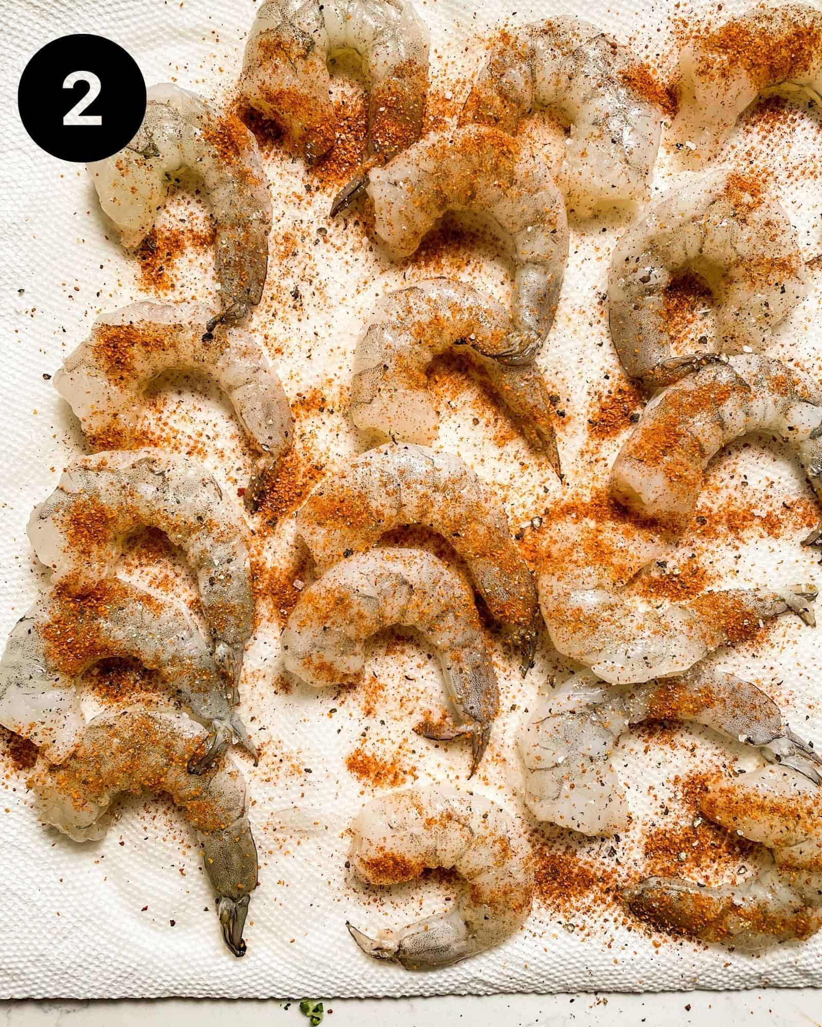 shrimp on a paper towel coated in seasonings, salt, and pepper.