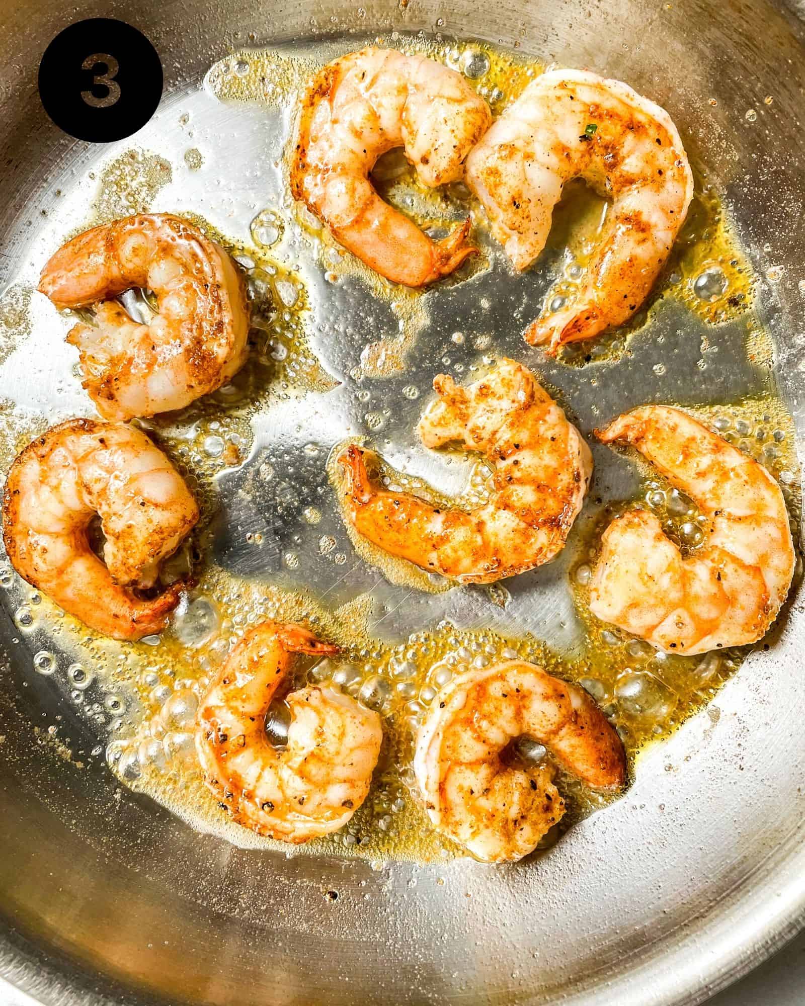 shrimp being cooked in a skillet.