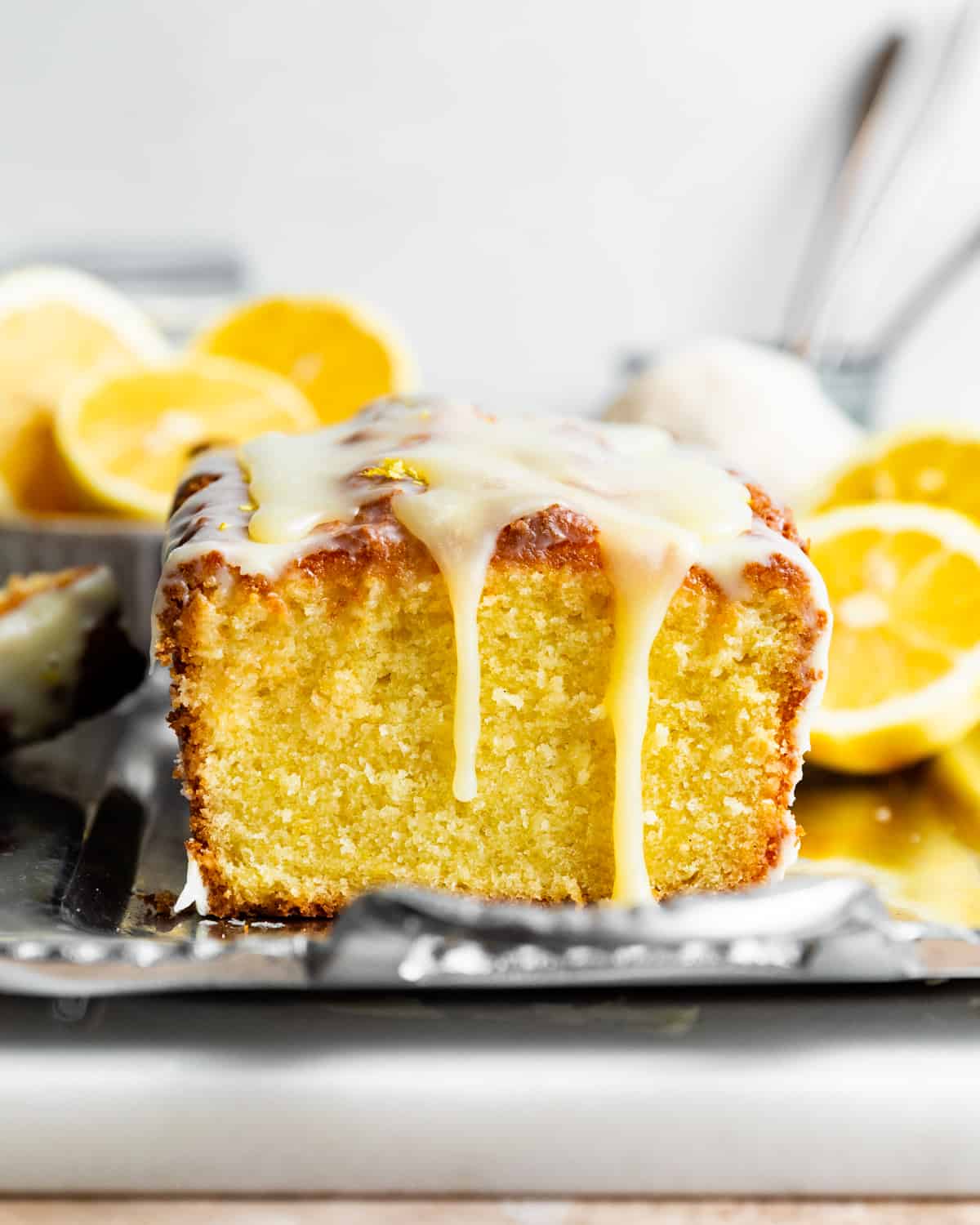a lemon loaf on a serving tray with lemon glaze dripping down.