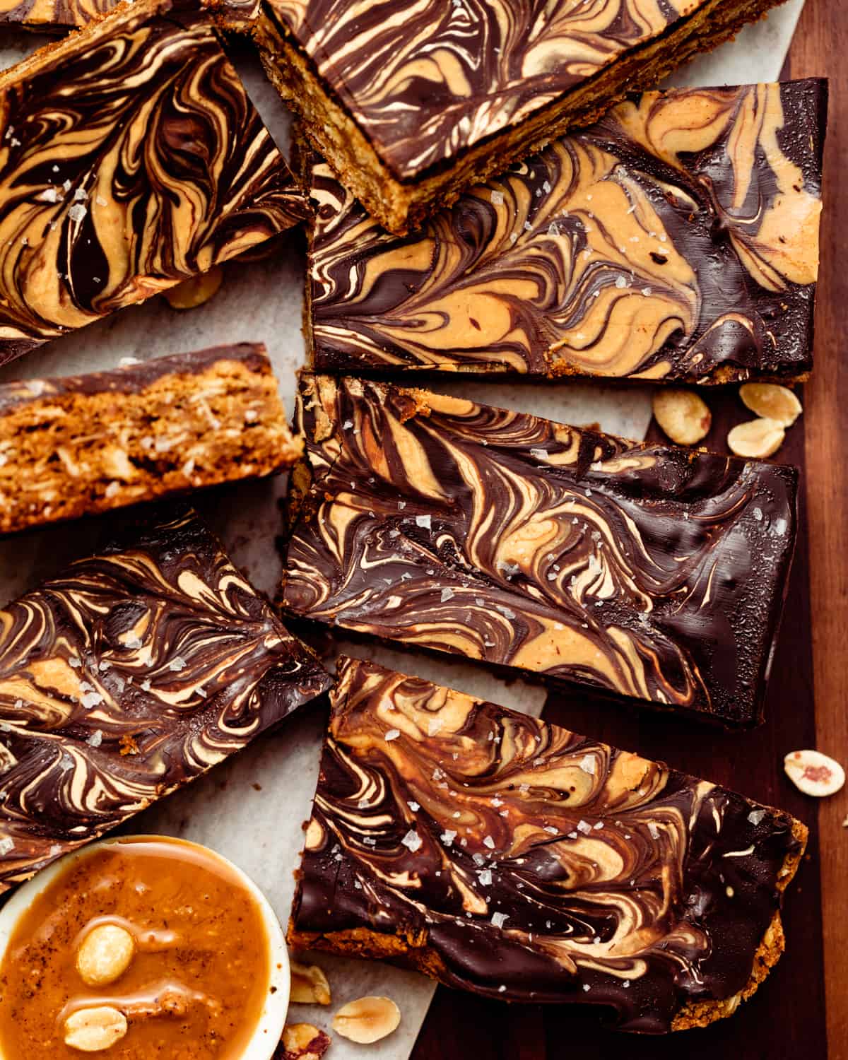 chocolate peanut butter oatmeal bars cut into squares and lined up together on a brown plate.