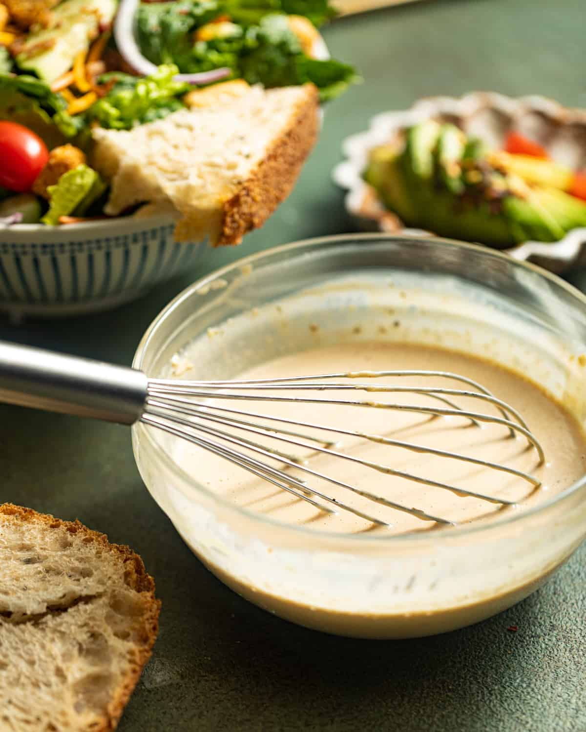 a bowl of balsamic dressing with a whisk.