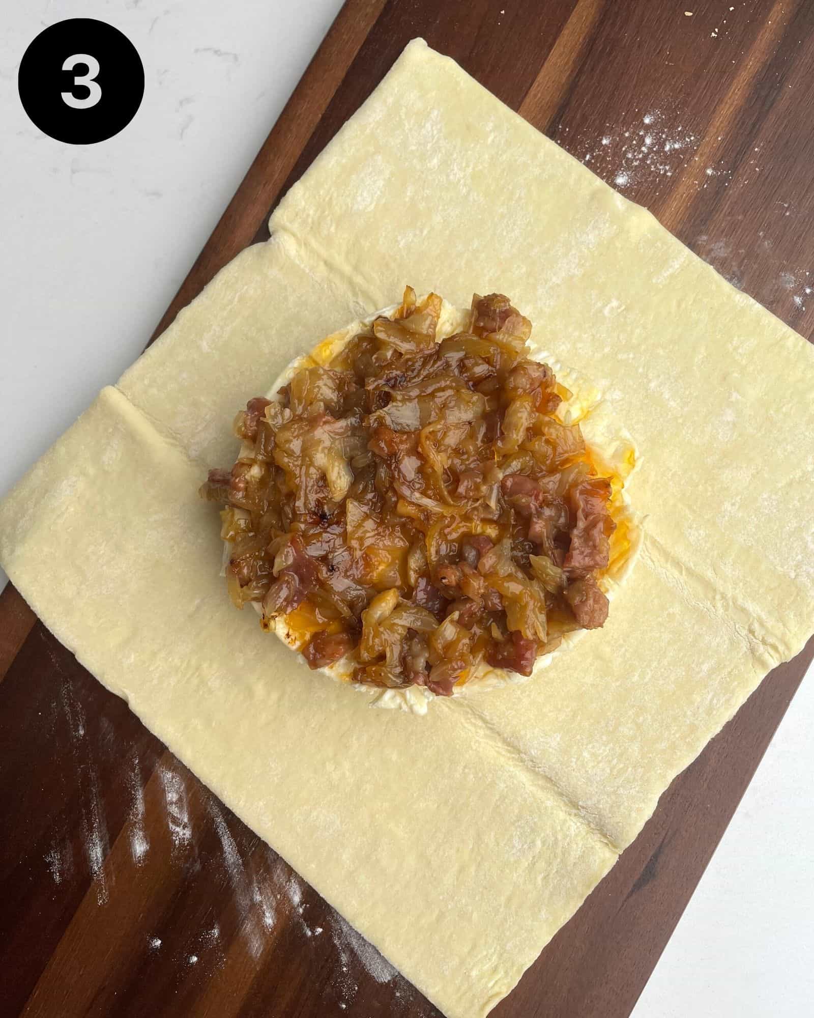 a wheel of brie topped with caramelized onions and apricot preserves.