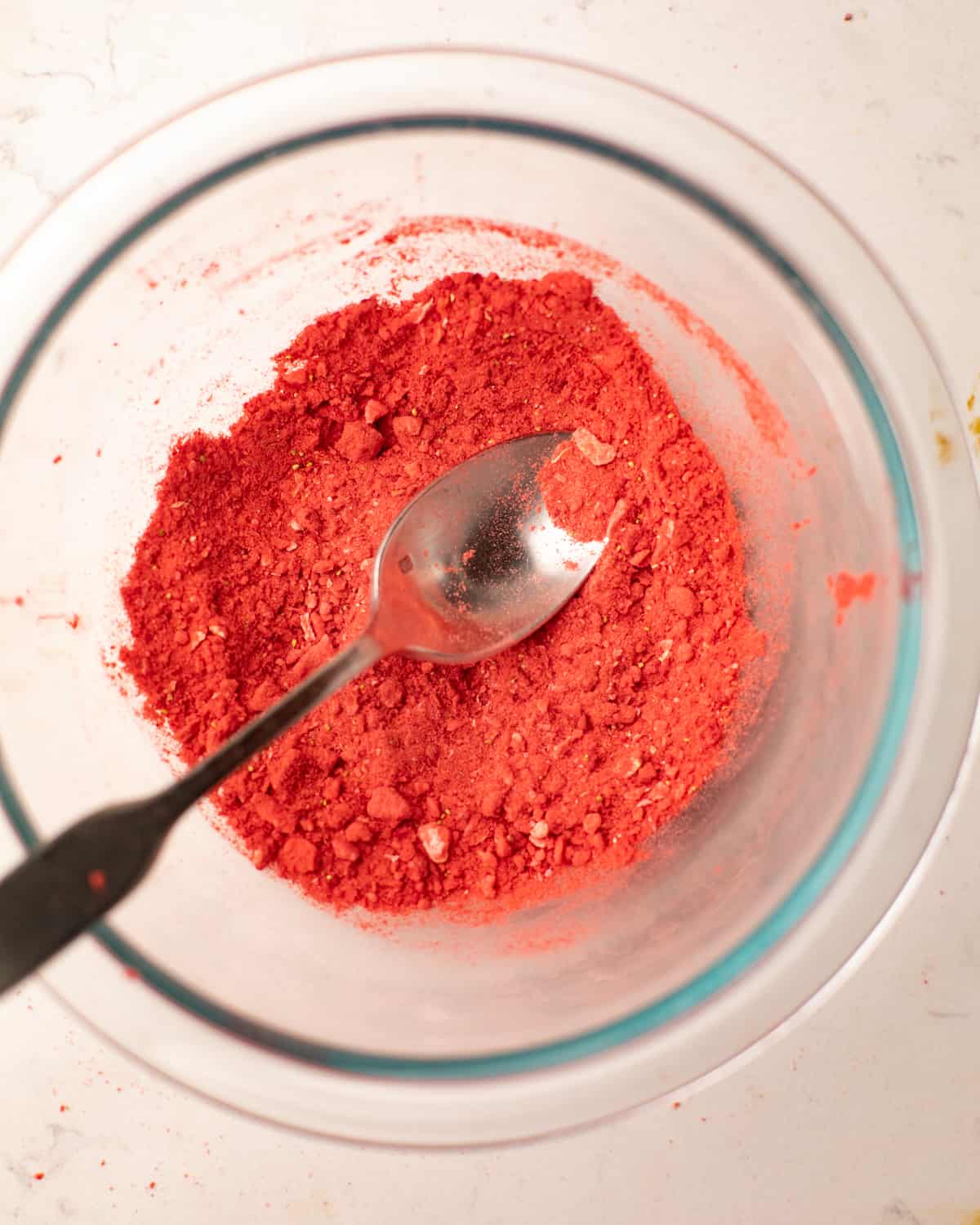 freeze-dried strawberries blended into a powder in a bowl with a spoon.