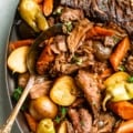 Mississippi Pot Roast in a serving dish with potatoes and carrots.