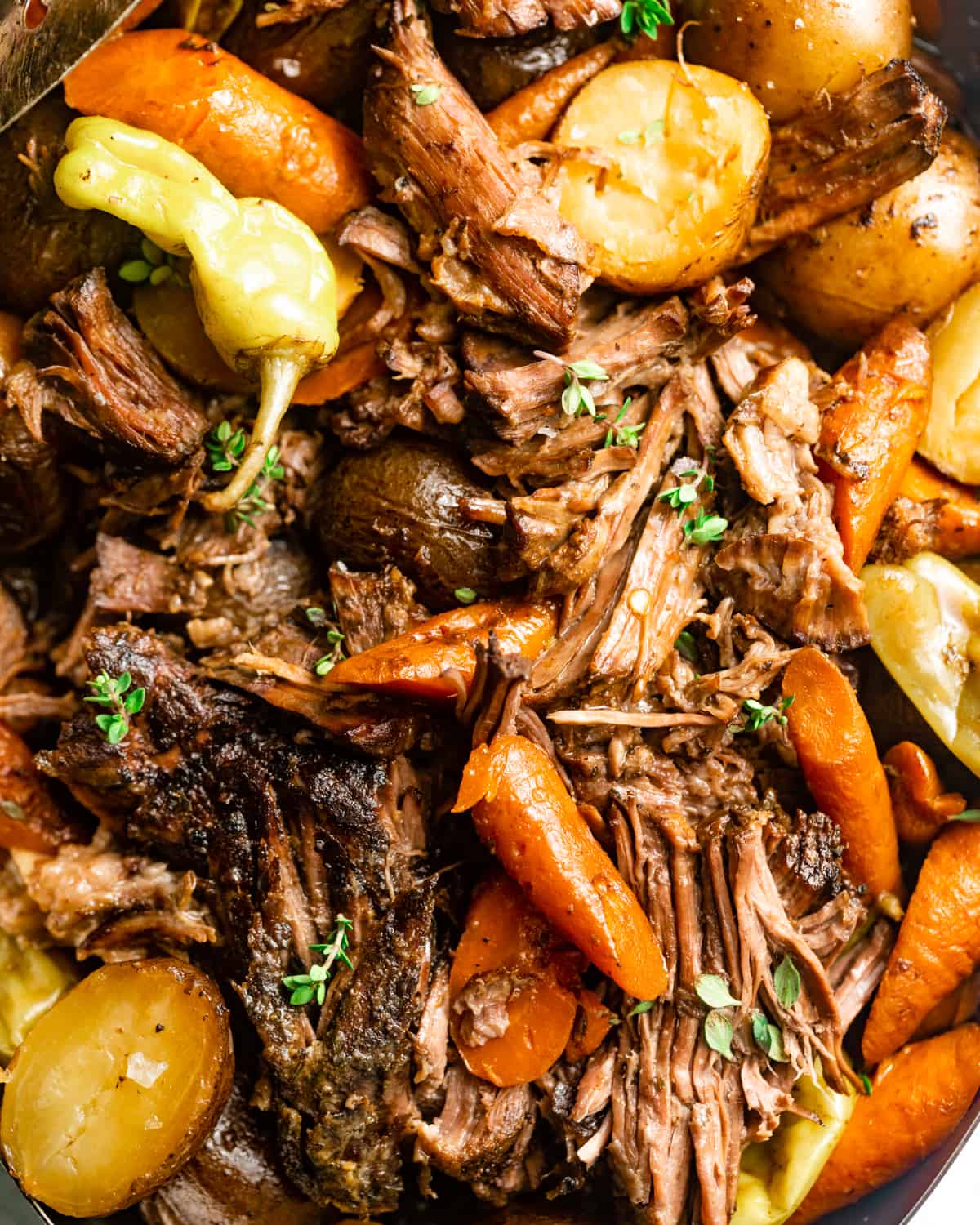 up close photo of mississippi pot roast cut into pieces with carrots and potatoes.