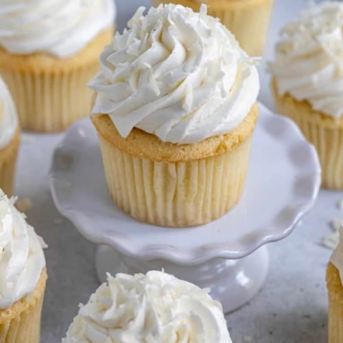 coconut cupcakes with frosting on top and sprinkled with coconut flakes.
