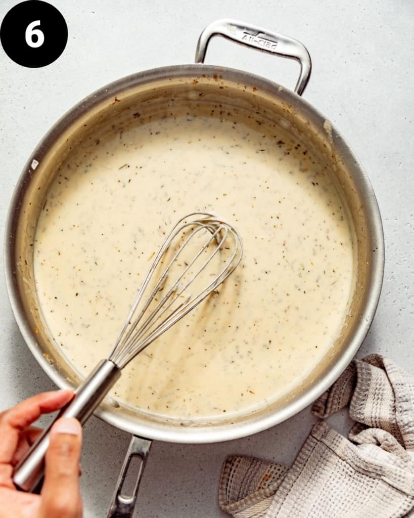 white wine sauce in a pan with a whisk.