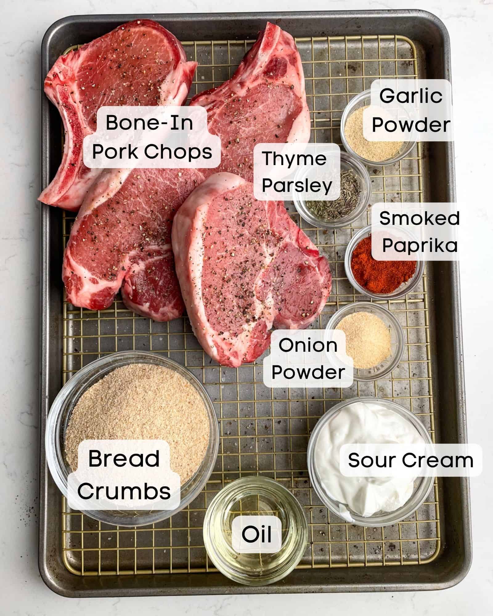 ingredients to make shake and bake pork chops - bone in pork chops, garlic powder, smoked paprika, onion powder, thyme, parsley, breadcrumbs, sour cream, and oil.