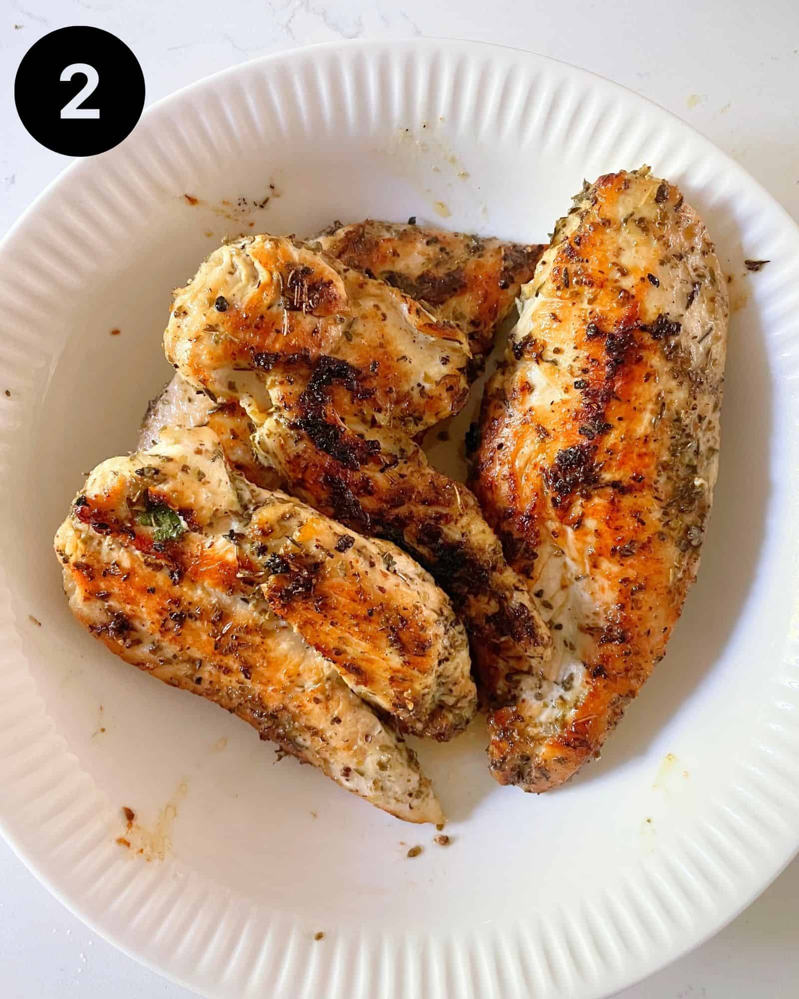 grilled chicken breasts in a bowl.