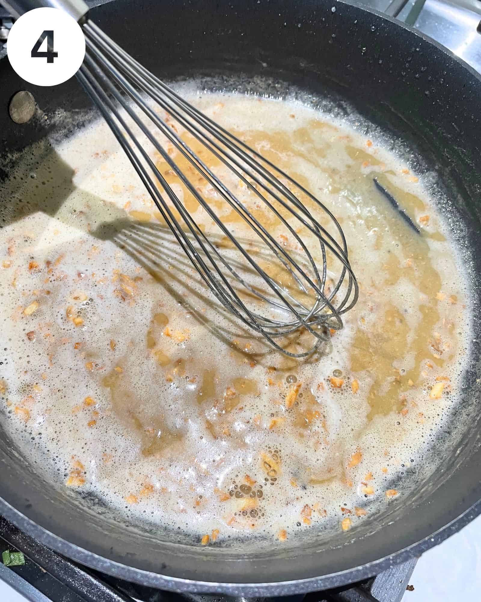 butter, minced garlic, and flour in a pan with a whisk.