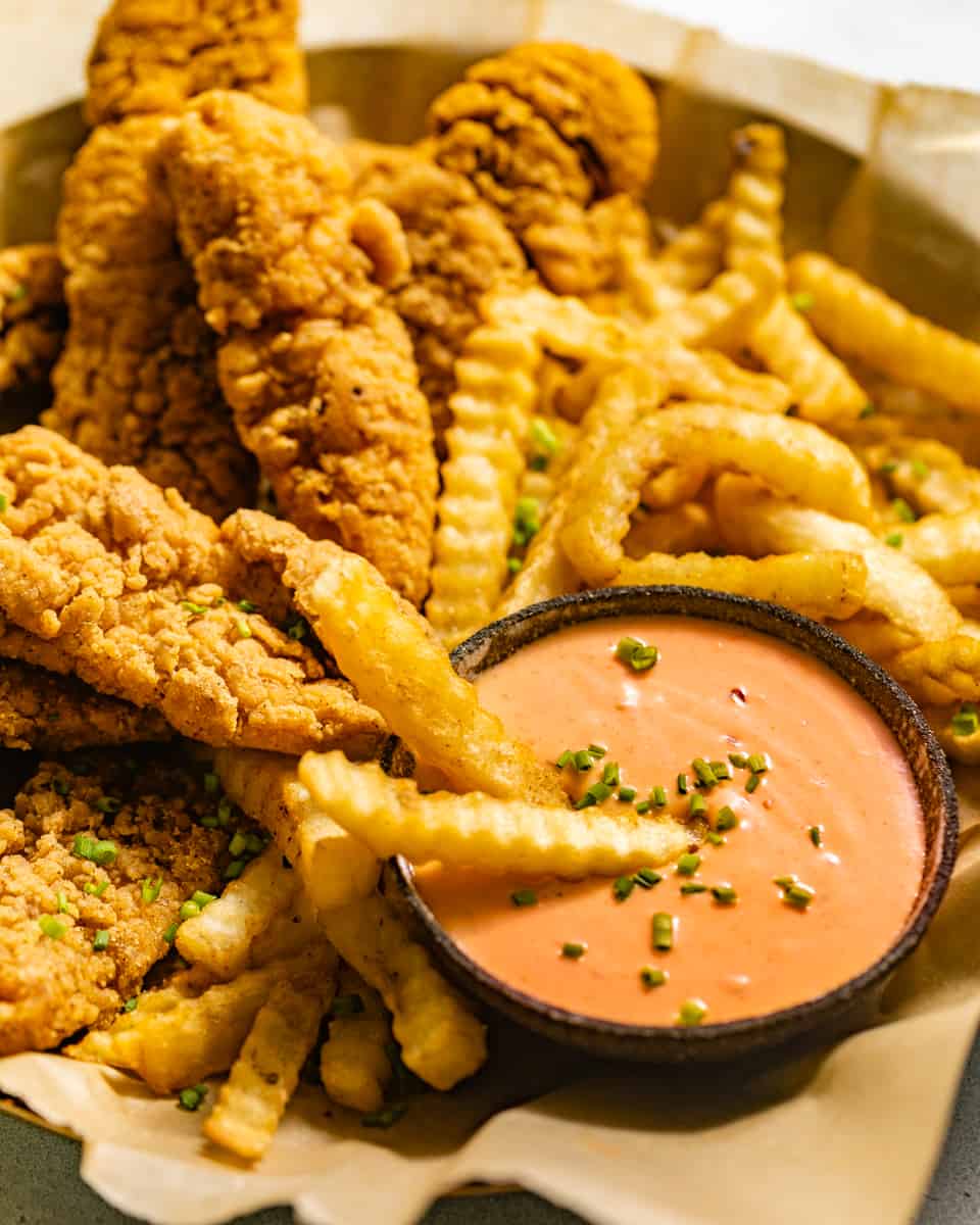 boom boom sauce on a plate with chicken tenders and french fries.