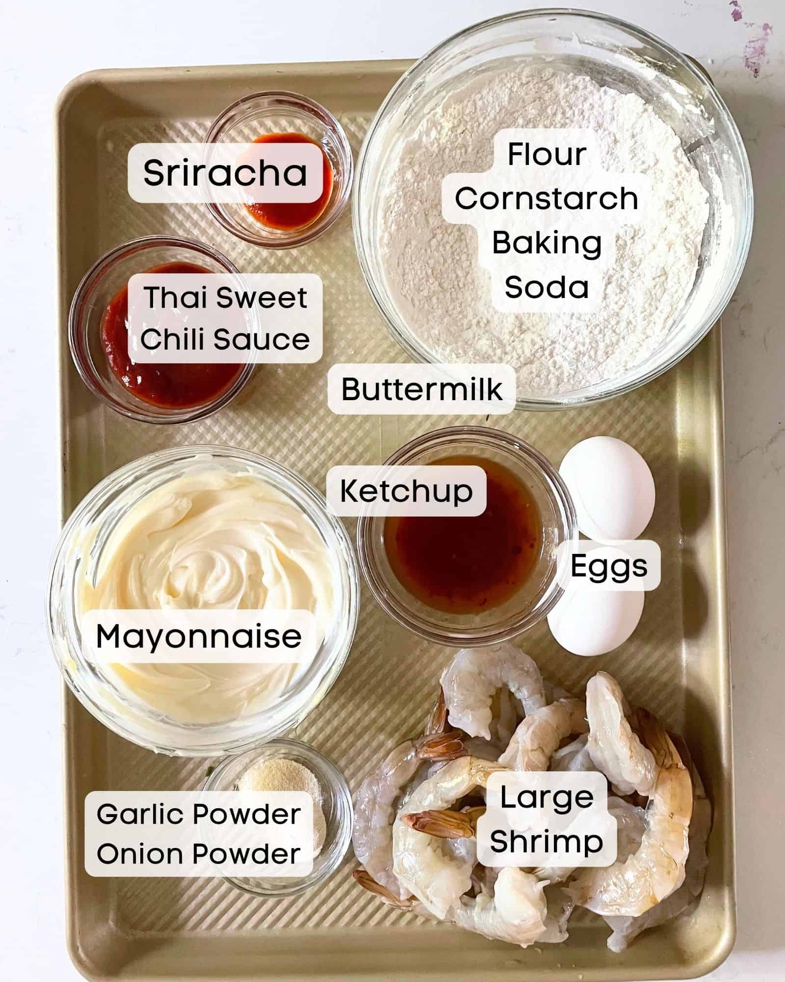 ingredients to make boom boom shrimp - large shrimp, mayonnaise, sriracha, sweet chili sauce, flour, cornstarch, baking soda, garlic powder, eggs, buttermilk, ketchup, and salt.