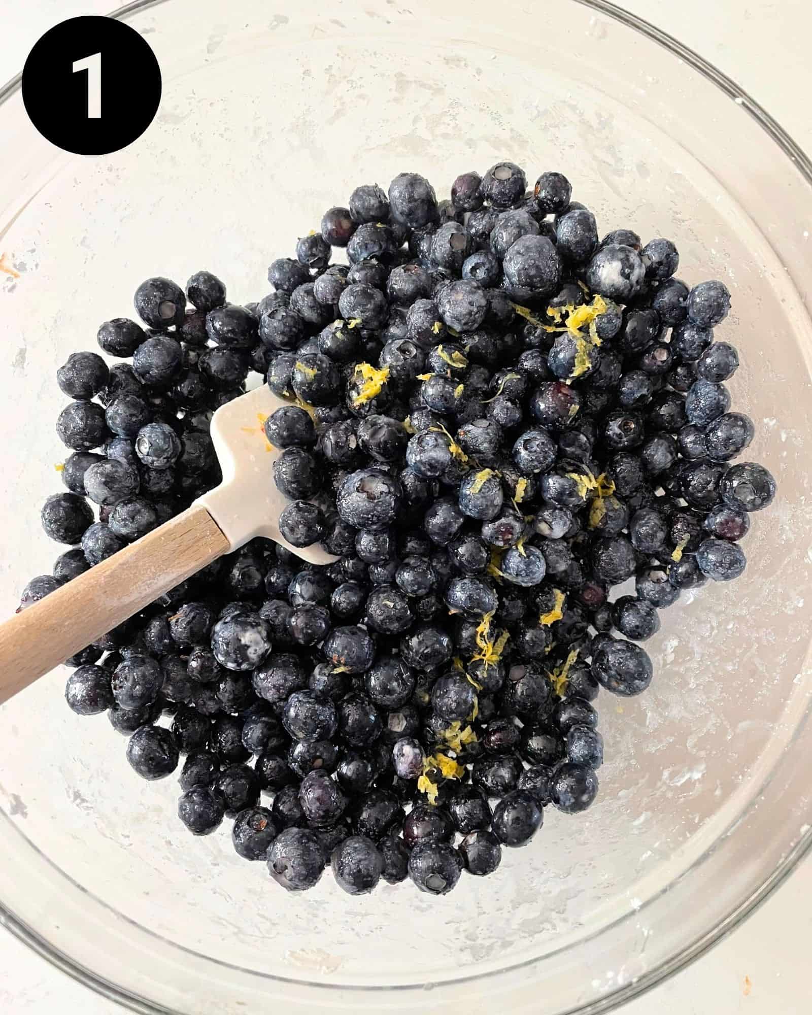blueberries mixed together in a bowl with sugar, cornstarch, lemon juice, and lemon zest.