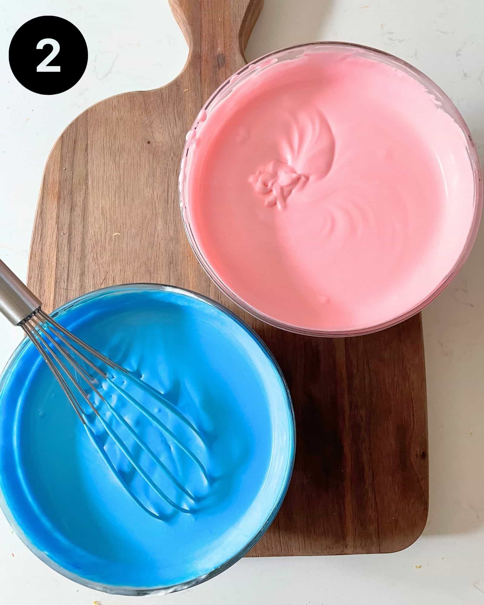 cotton candy ice cream divided into two bowls. one bowl with pink food coloring and the other bowl with blue food coloring.