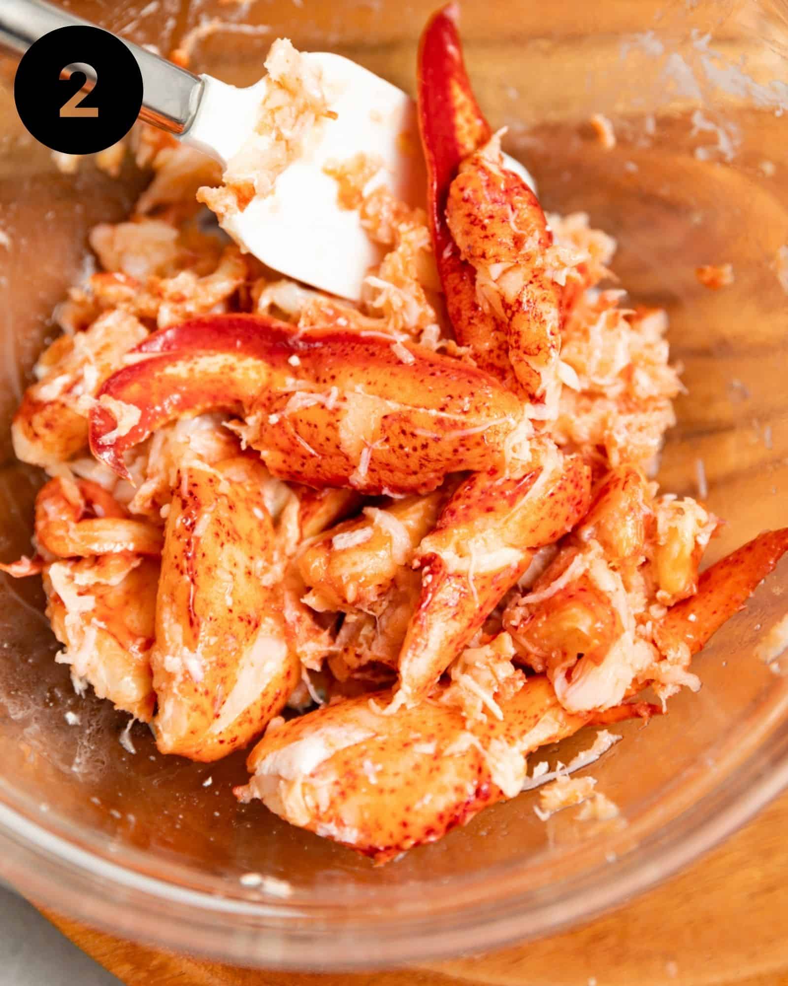 lobster meat in a bowl tossed in melted butter and seasonings.