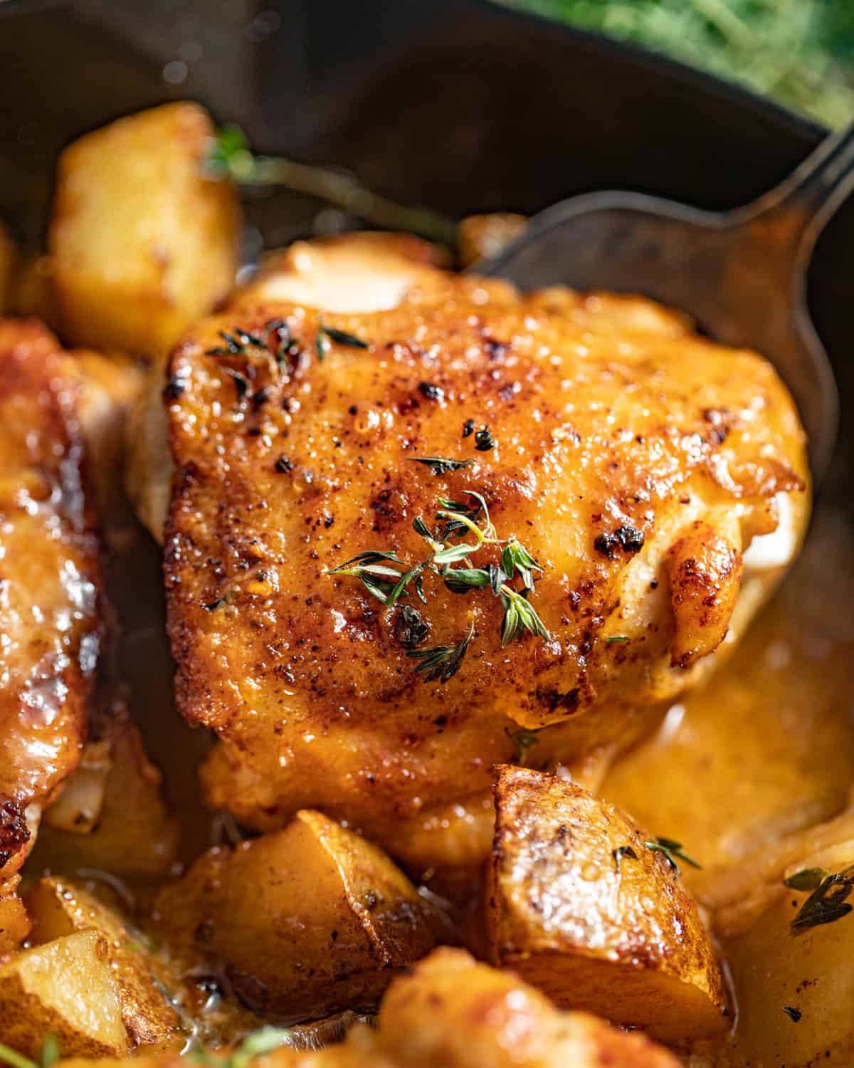 A spoon scooping up a maple dijon chicken thigh.
