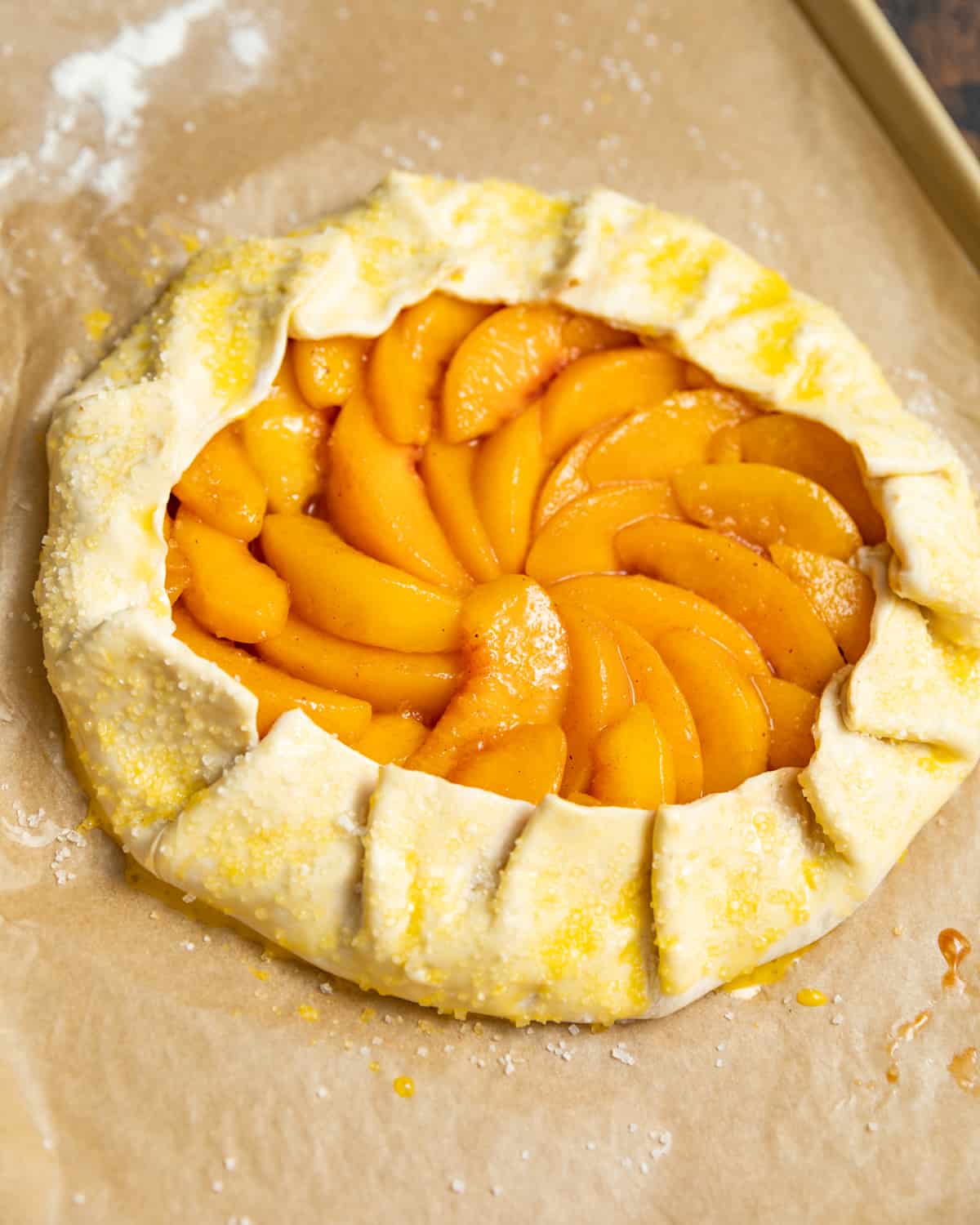 Puff pastry folded into a galette around peaches and brushed with egg wash.