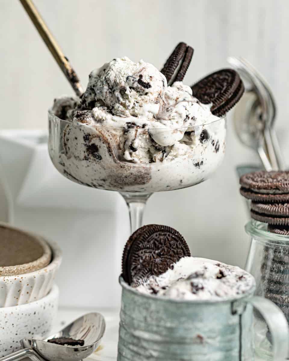 homemade oreo ice cream in a tall glass with oreo cookies and a gold spoon.