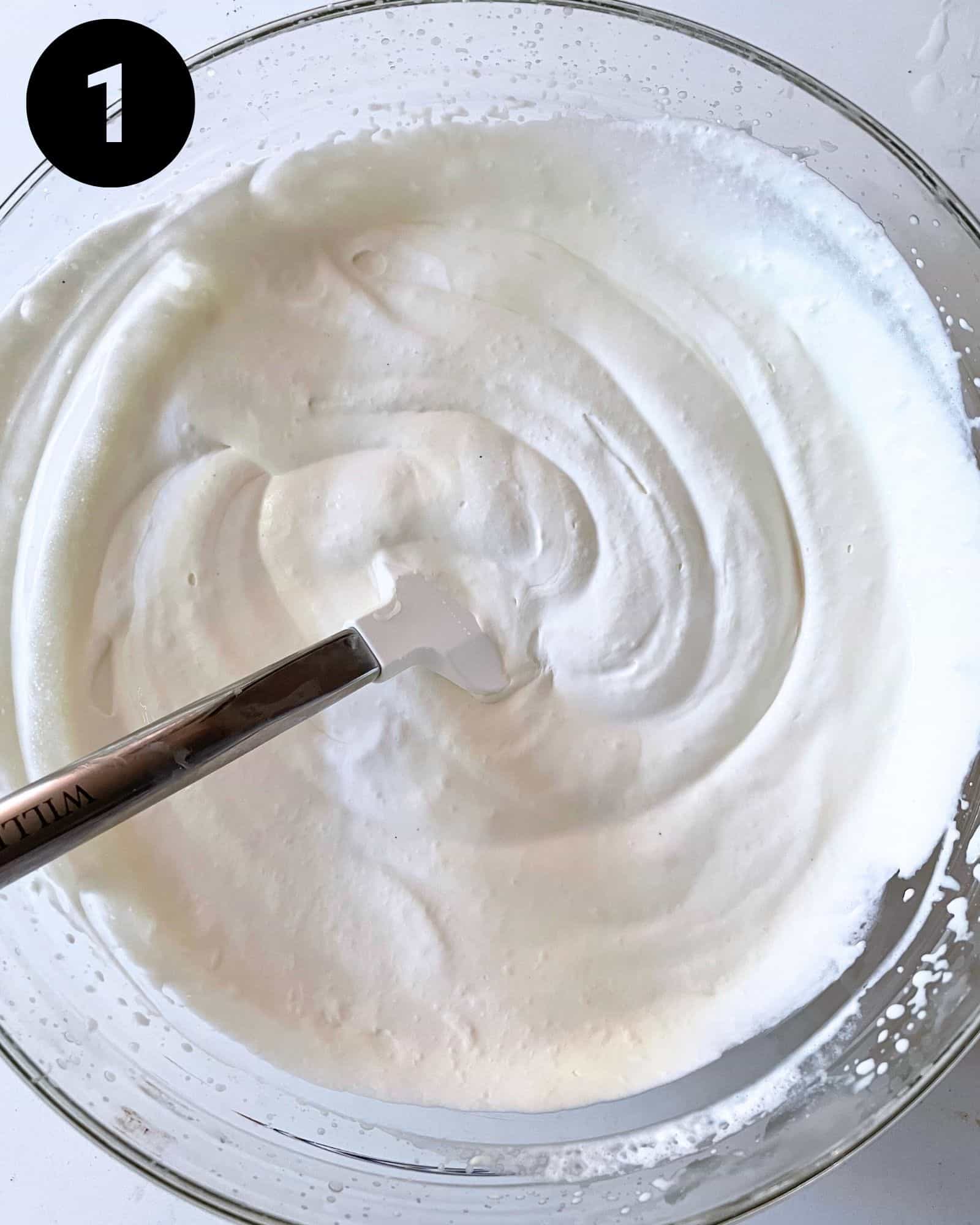 whipped cream in a bowl with marshmallow fluff, vanilla extract, and sweetened condensed milk.