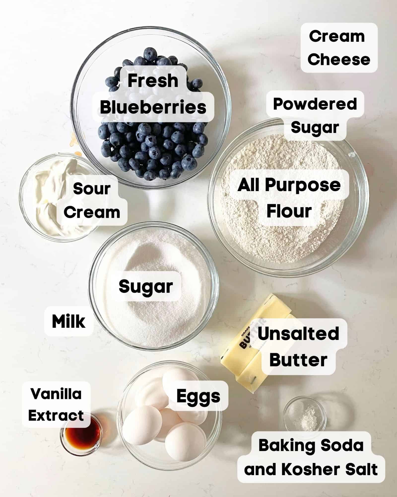 ingredients to make blueberry pound cake - flour, sugar, butter, eggs, vanilla extract, baking soda, salt, blueberries, and sour cream.