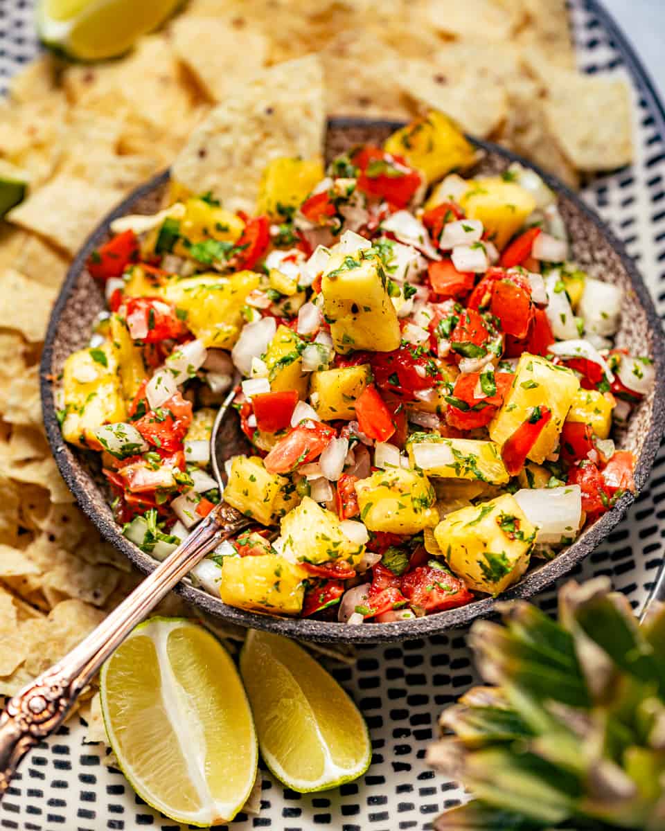 pineapple pico de gallo on a serving dish with tortilla chips.