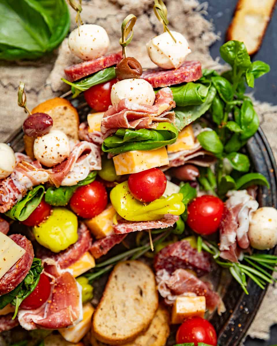 charcuterie skewers garnished with fresh herbs.