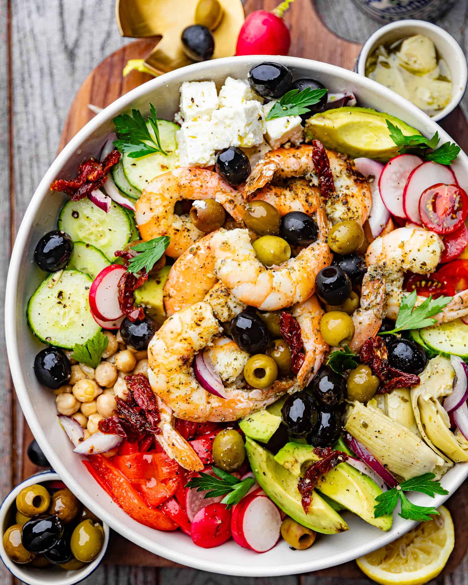 Mediterranean Shrimp Salad in a bowl with vegetables and shrimp on top.
