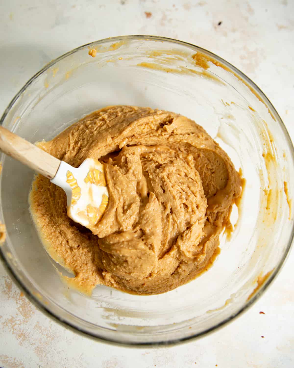A spatula in a mixing bowl of peanut butter truffle filling.