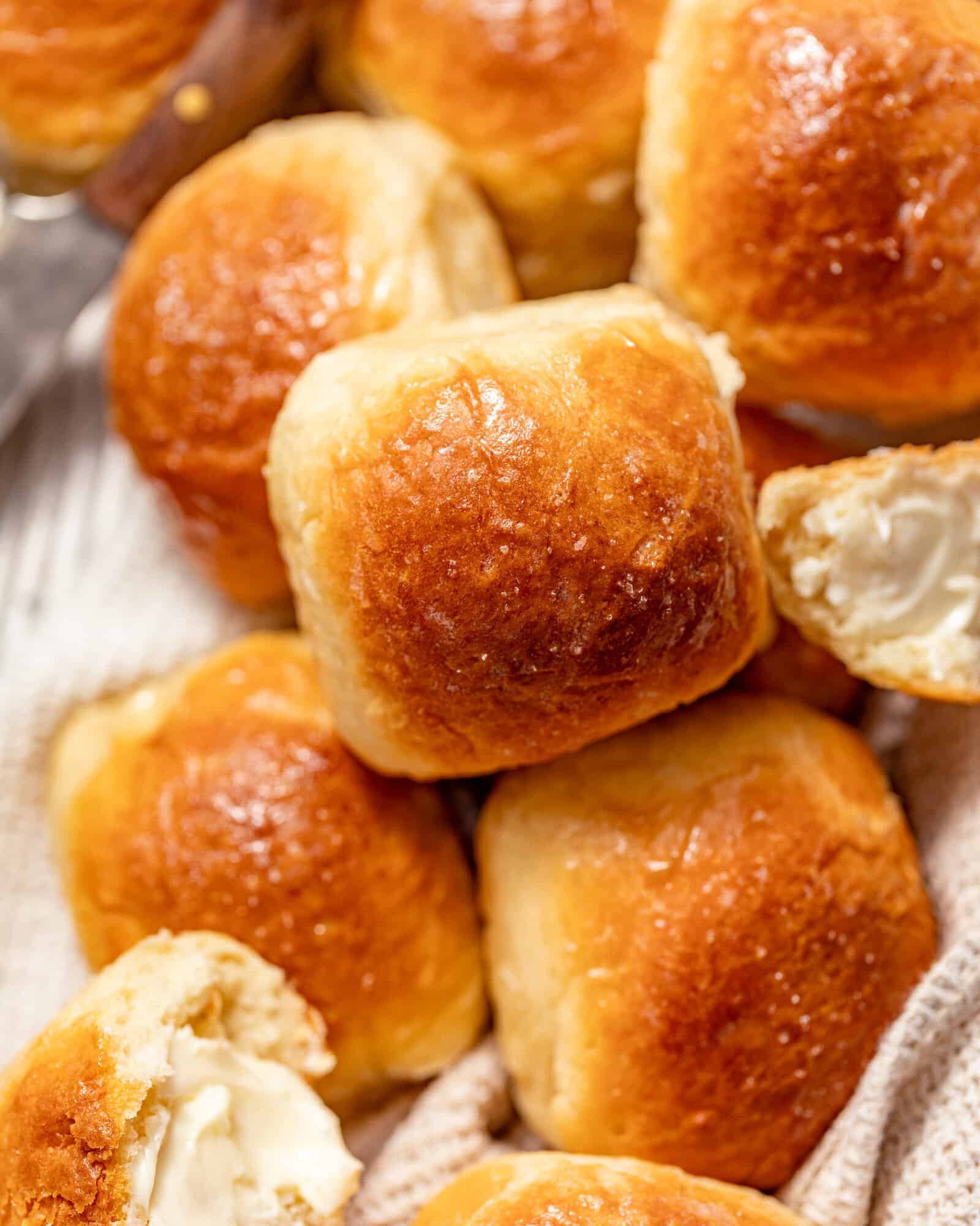 brown and serve rolls in a basket topped with flaky sea salt