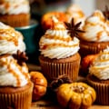 pumpkin cupcakes on a brown board with salted caramel and mini pumpkins.