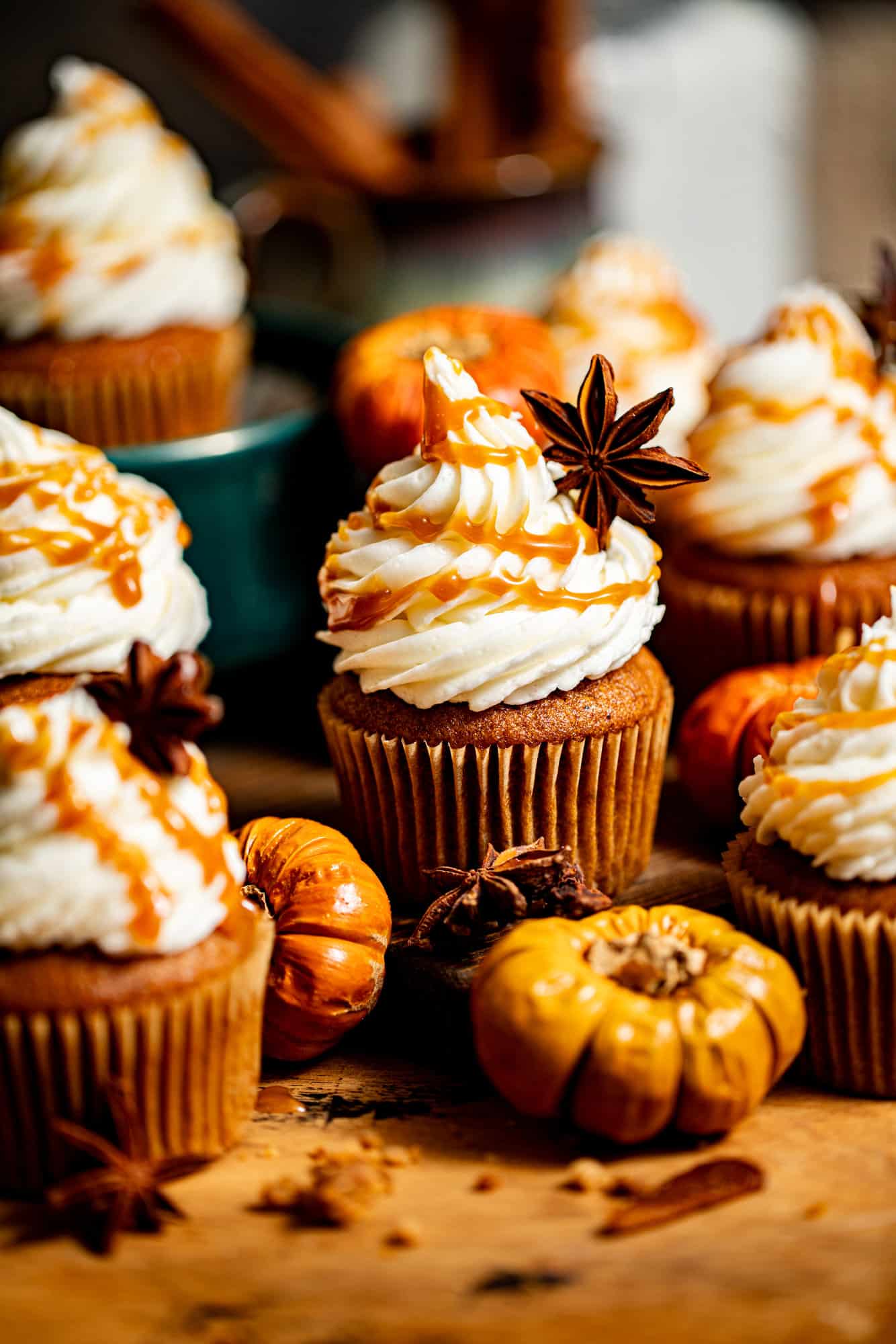 salted caramel pumpkin cupcakes with small pumpkins around it