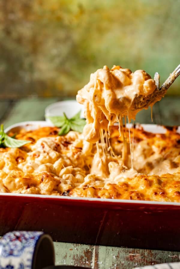 smoked gouda mac and cheese in a pan with a spoon showing the cheese pull.