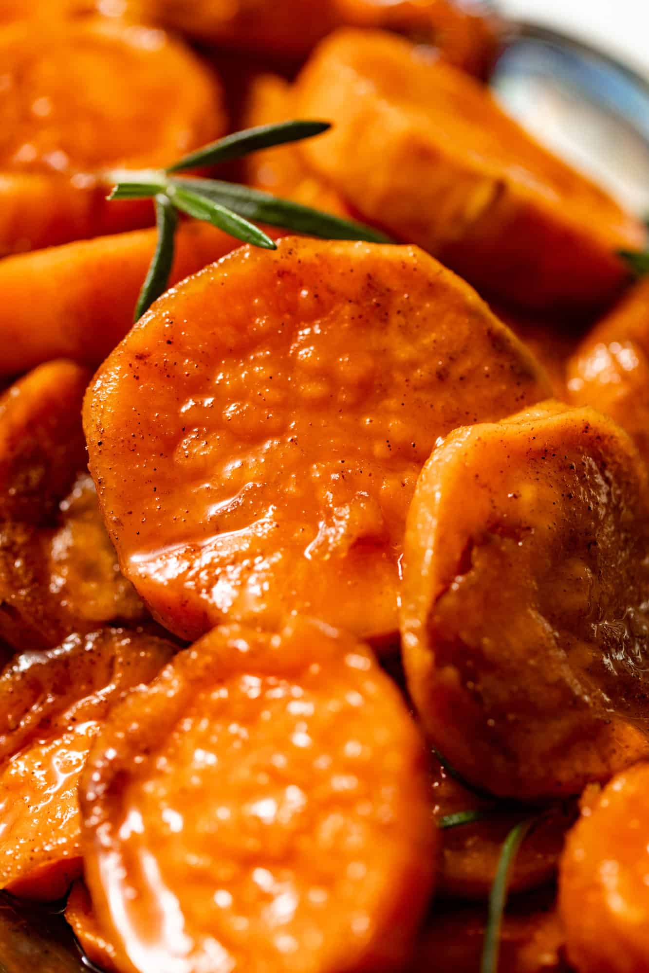 up close photo of candied yams covered in a brown sugar glaze.