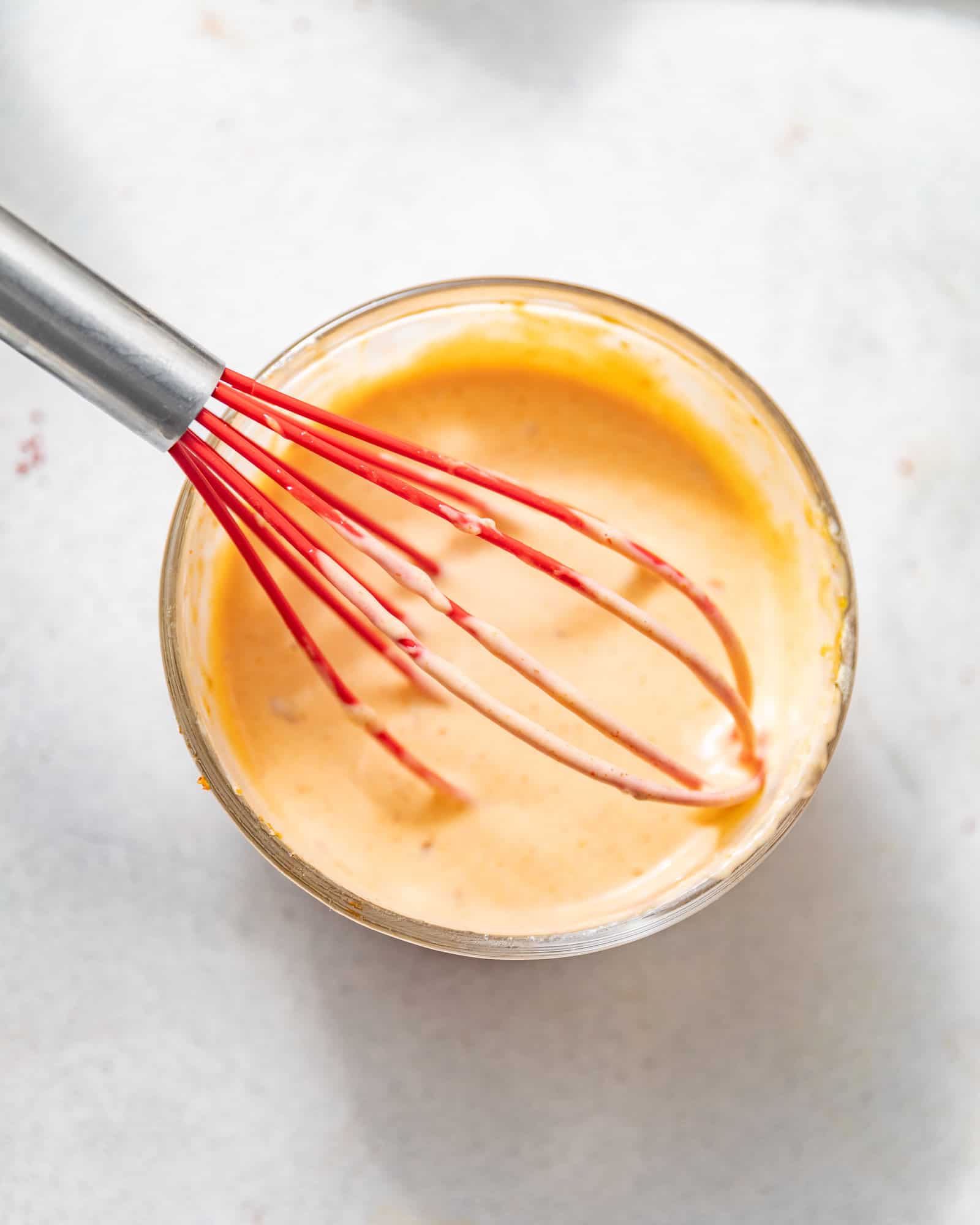 bang bang sauce in a small bowl with a whisk