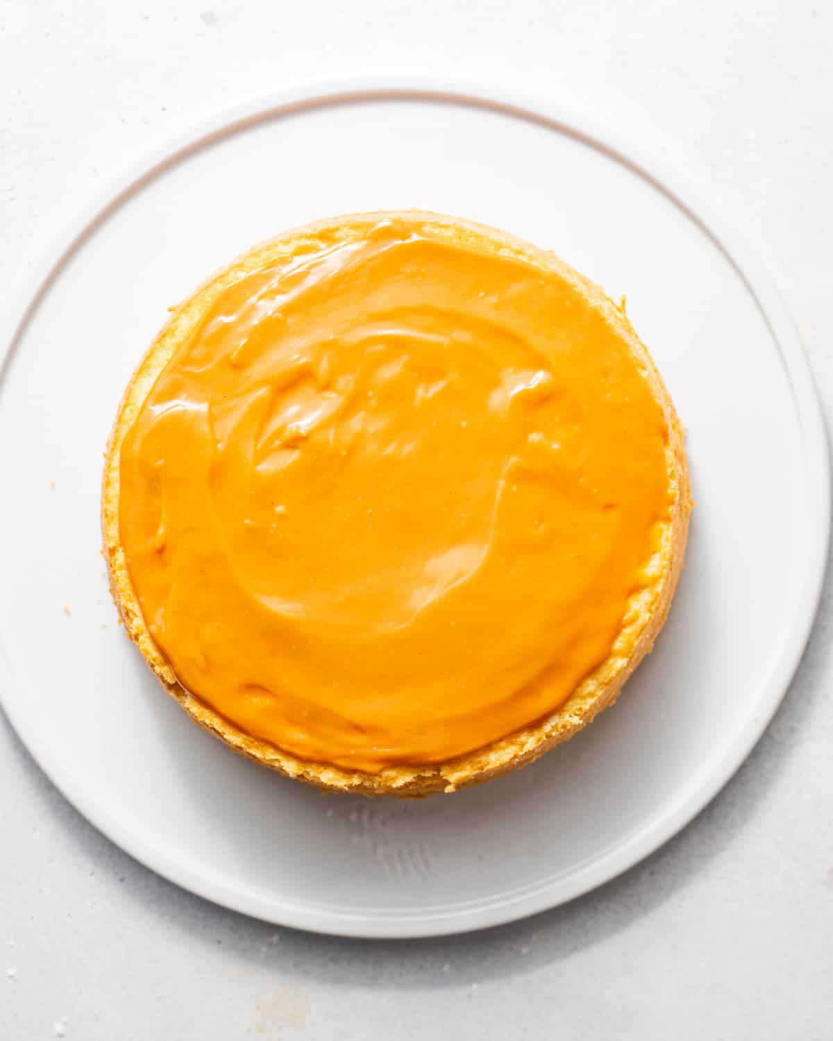 caramel frosting poured onto one of the cake layers.