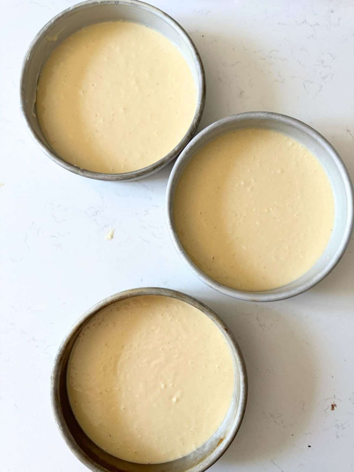 cake batter divided into 3 8 inch cake pans.