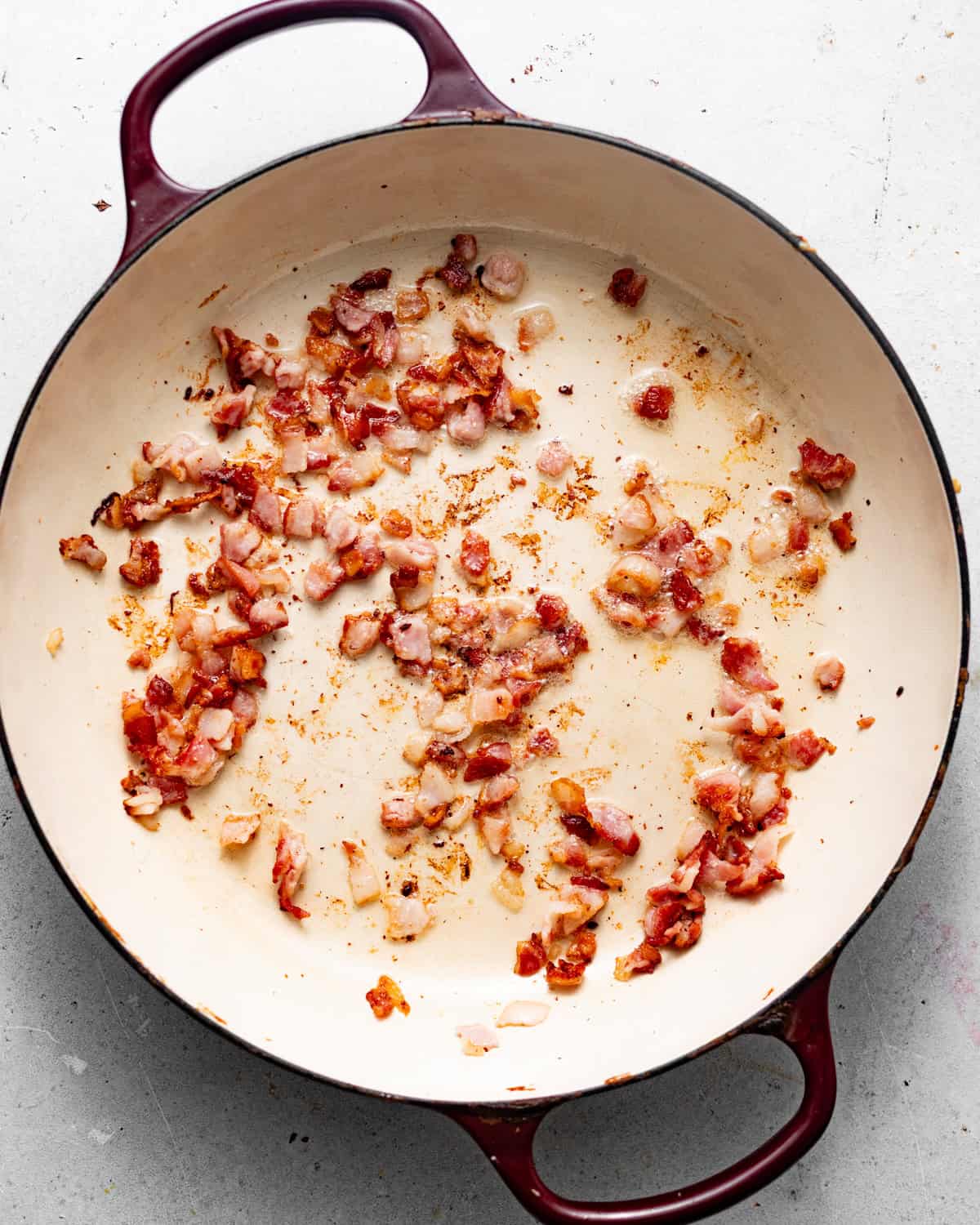 chopped bacon cooked in a large pan. 