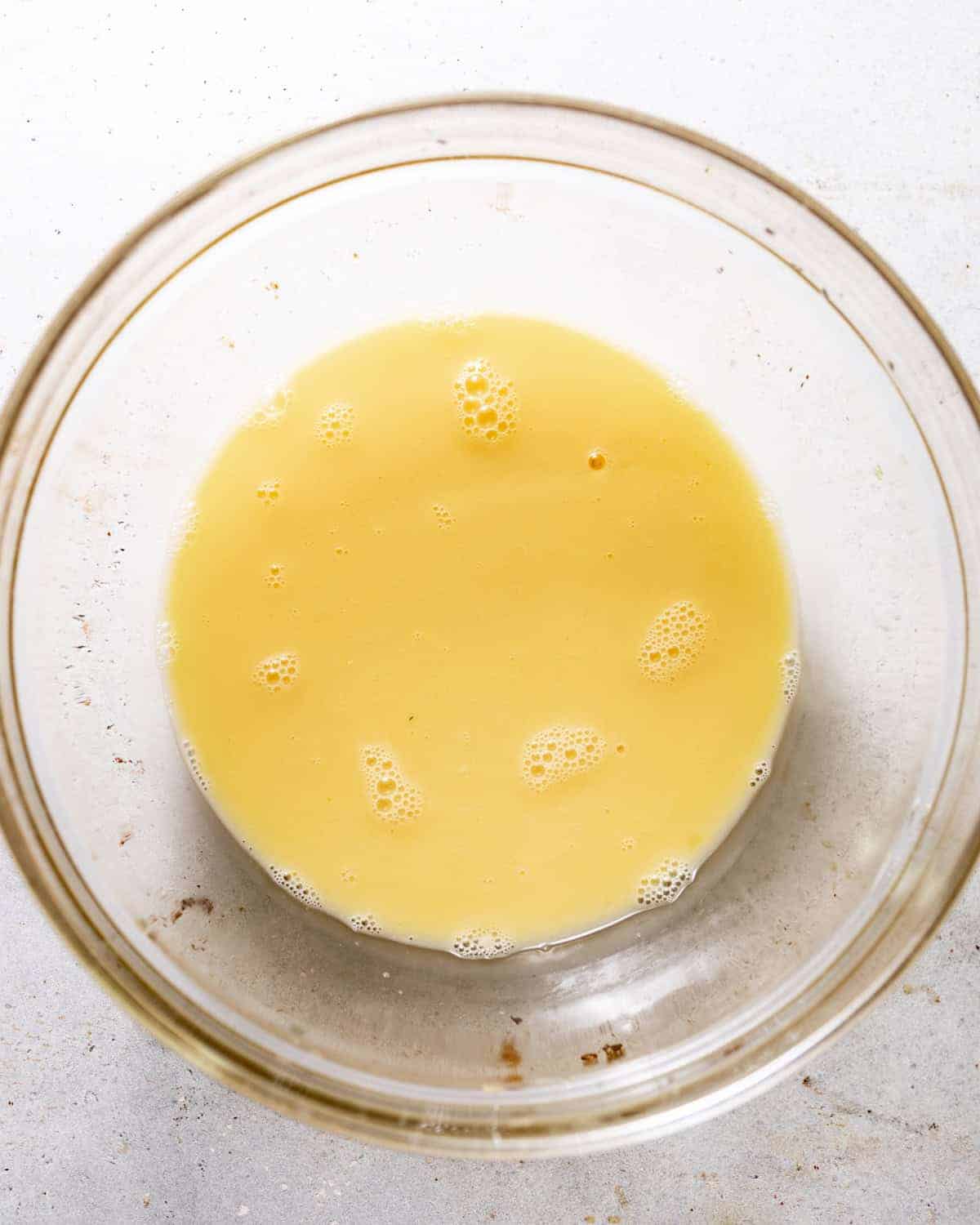 eggs and chicken broth whisked together in a bowl. 