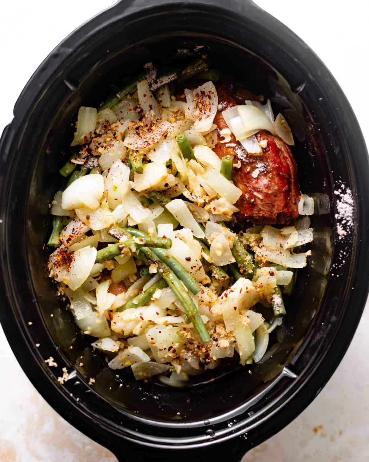 slow cooker green beans in the slow cooker with smoked turkey, onions, broth, seasonings, and garlic.