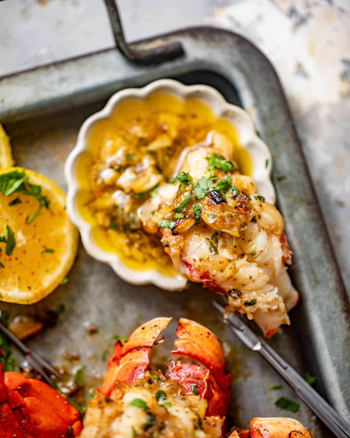 lobster meat dipped into a bowl of garlic butter sauce. 