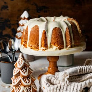 eggnog pound cake on a cake stand covered in spiced eggnog glaze and freshly grated nutmeg.