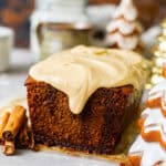 gingerbread loaf on a white surface with christmas trees in the background.