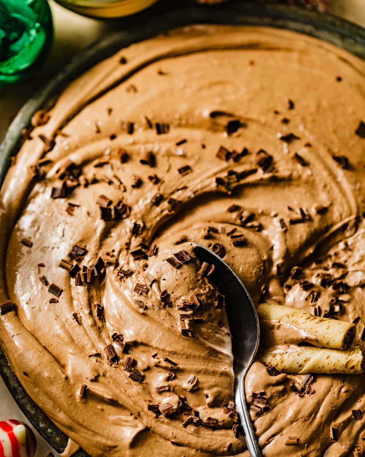 a spoon in the hot chocolate dip topped with chocolate shavings.