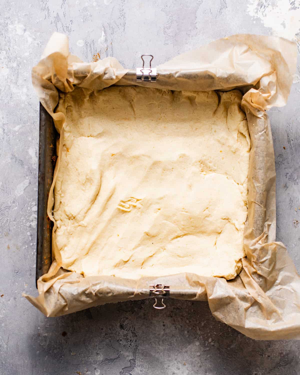 cookie dough pressed into a square baking pan. 
