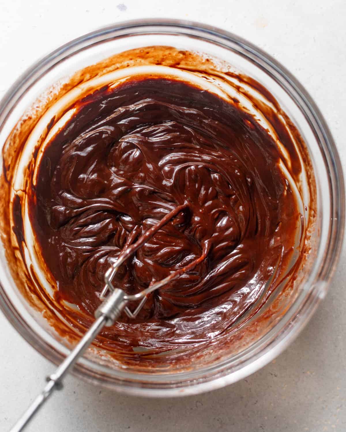 chocolate ganache in a mixing bowl with a whisk.