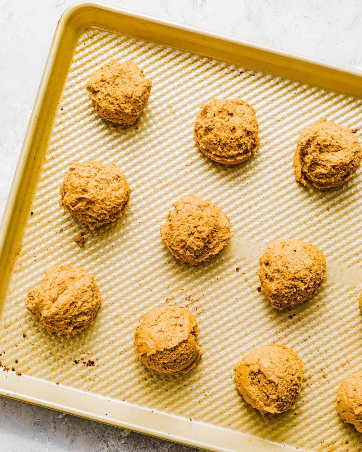 molasses cookie dough balls on a cookie sheet.