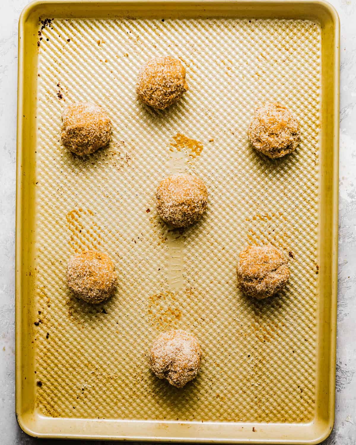 cookie dough balls on a baking sheet.