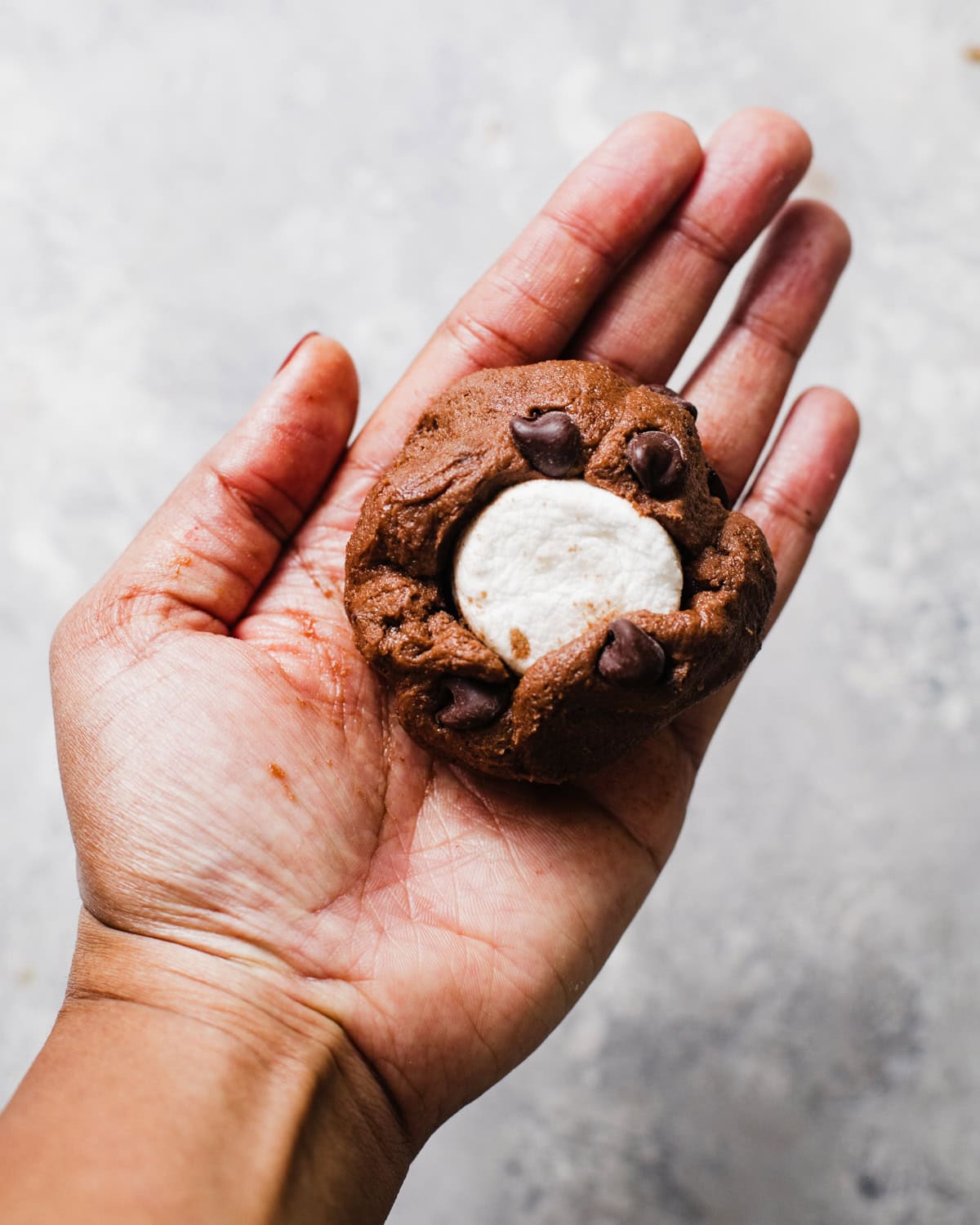 chocolate cookie dough with marshmallow in the middle of the dough.