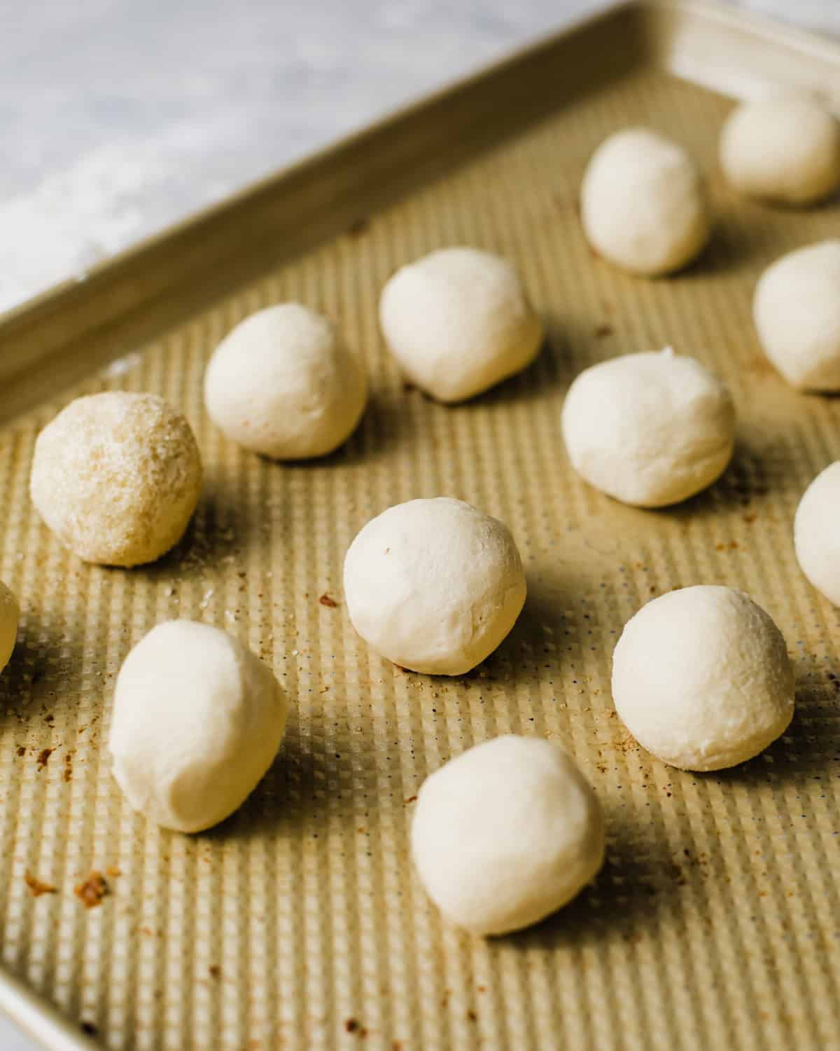 cookie dough balls on a baking sheet.